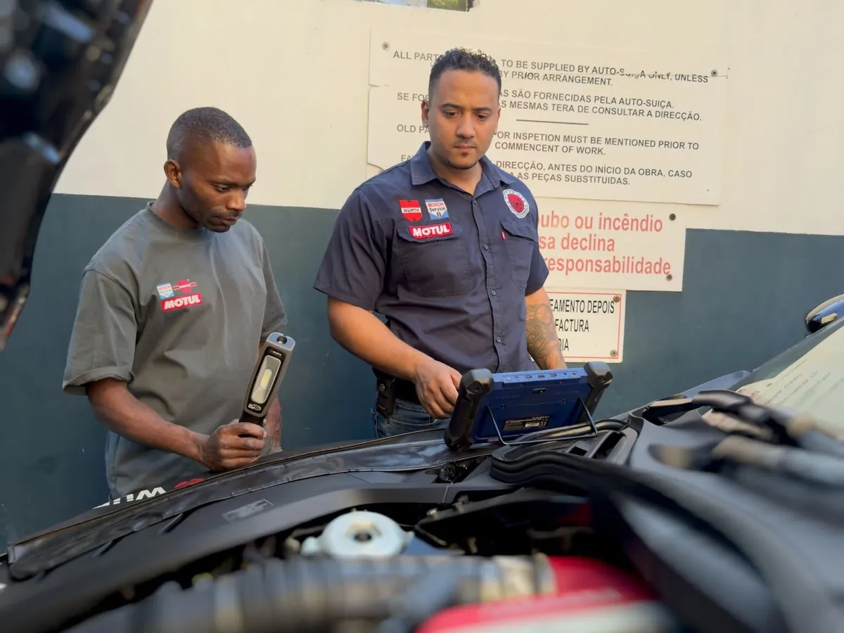 Mecânicos da Auto Suíça a fazer o diagnóstico eletrónico de uma viatura com um tablet de diagnóstico